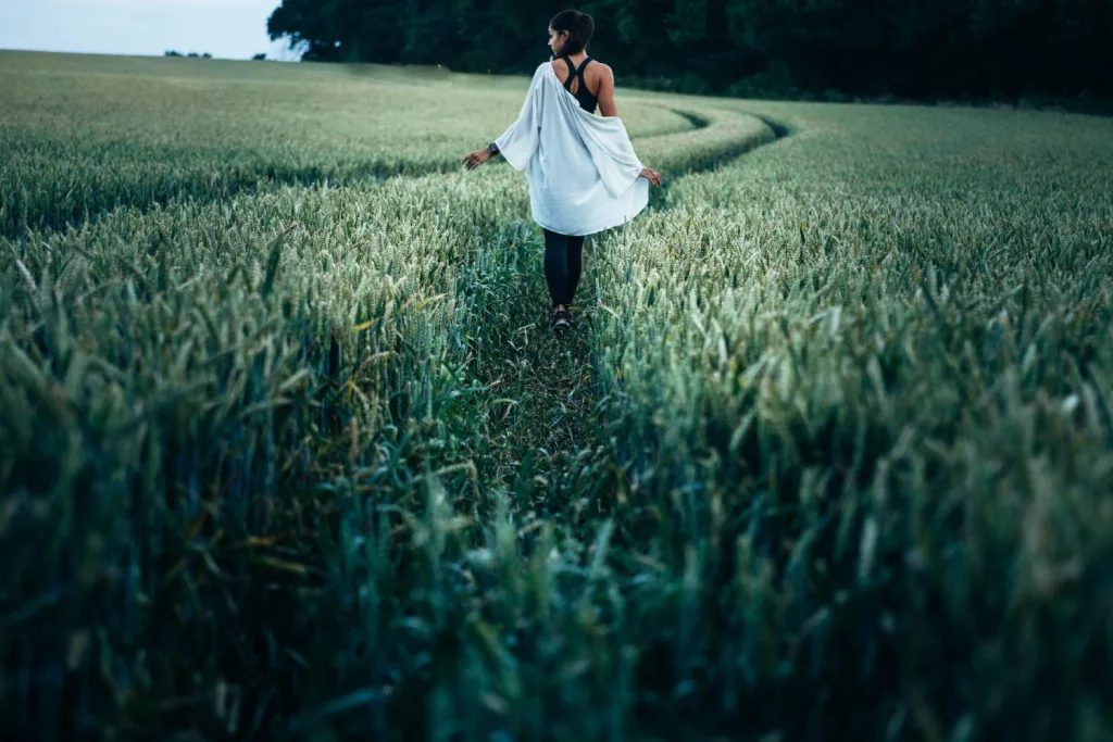 woman walking in green fields